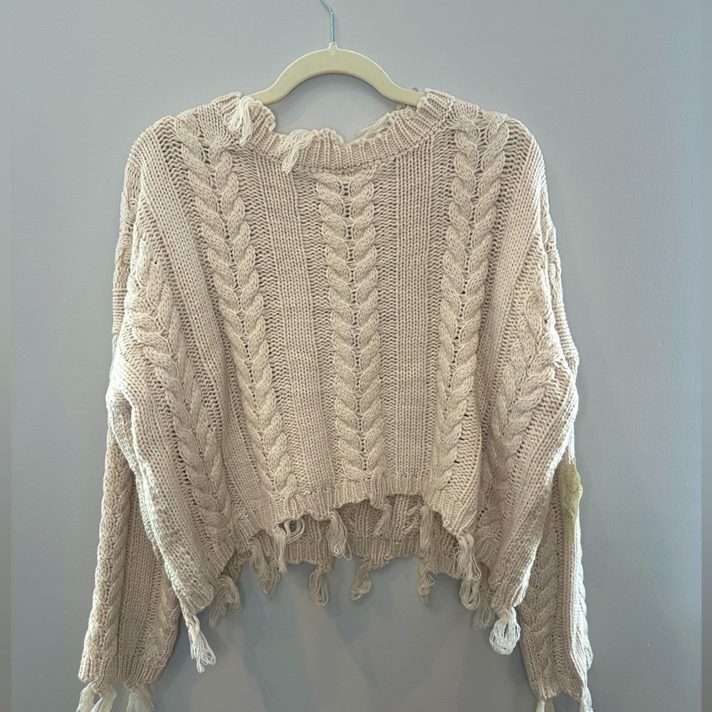 Cream cable knit sweater with frayed fringe detailing. NWT size XS